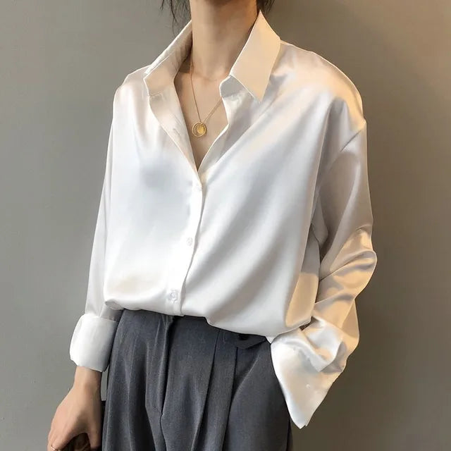 "Luxe Celeste satijnen blouse, vloeiende stof, lange mouwen, subtiele glans, elegante kraag, verfijnde stijl."