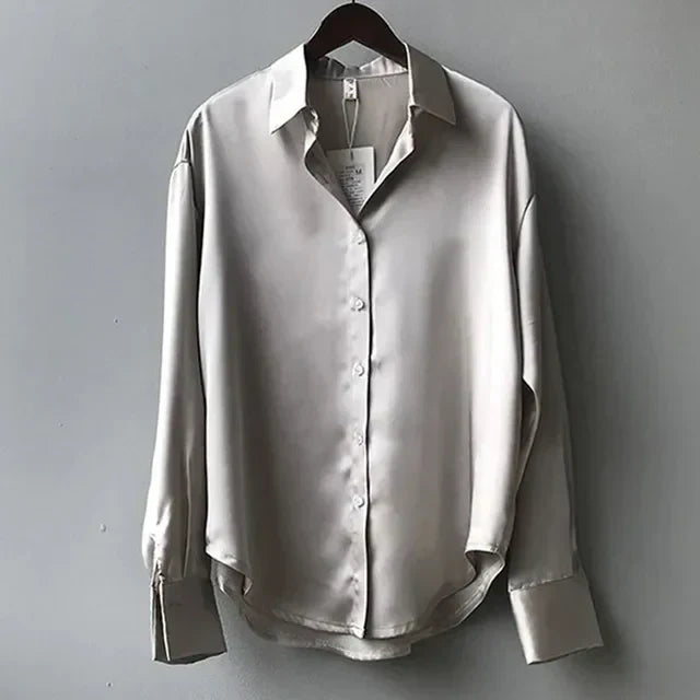 "Luxe Celeste satijnen blouse, vloeiende stof, lange mouwen, subtiele glans, elegante kraag, verfijnde stijl."