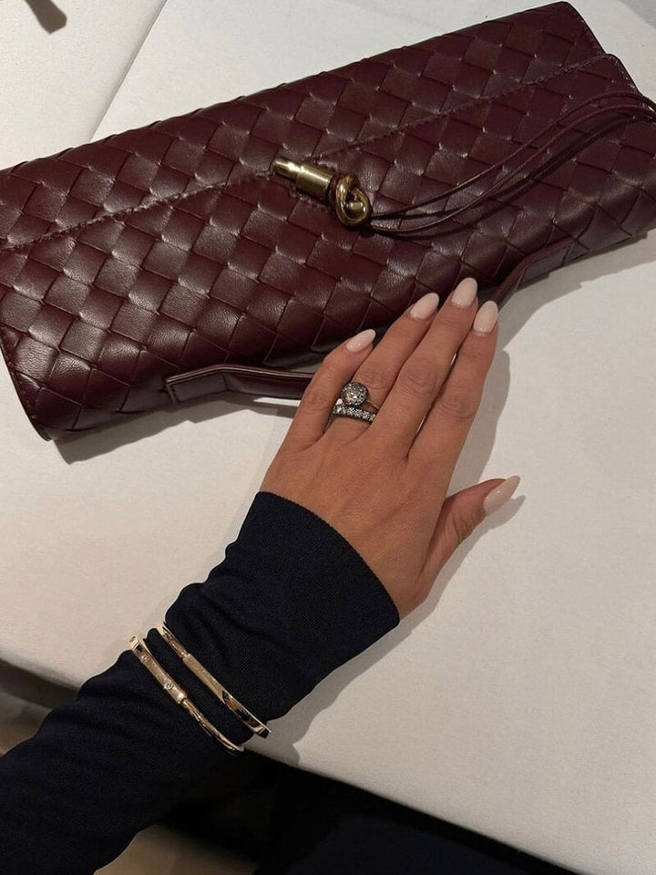 "Luxe geweven handtas in zwart met gouden sluiting, elegant en stijlvol ontwerp voor dames, ideaal voor elke gelegenheid."
