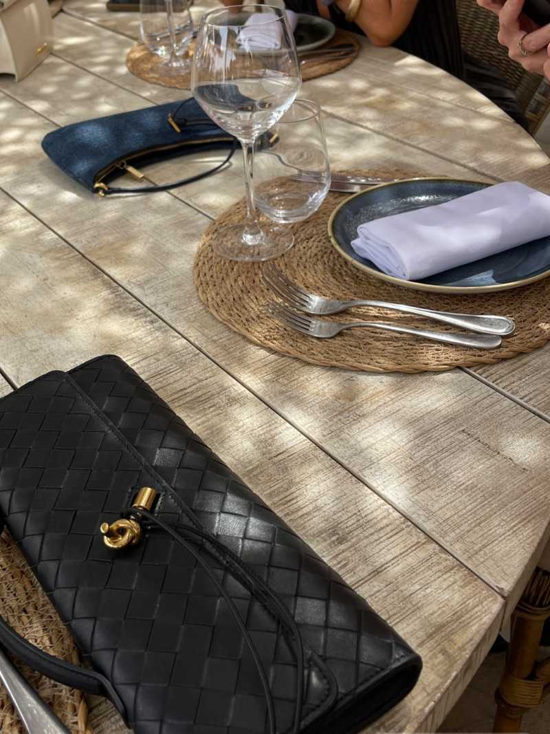"Luxe geweven handtas in zwart met gouden sluiting, elegant en stijlvol ontwerp voor dames, ideaal voor elke gelegenheid."