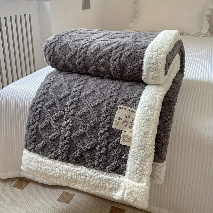 "Luxe sherpa deken in antraciet, gemaakt van premium geborstelde fleecestof, biedt ongeëvenaarde zachtheid en warmte."