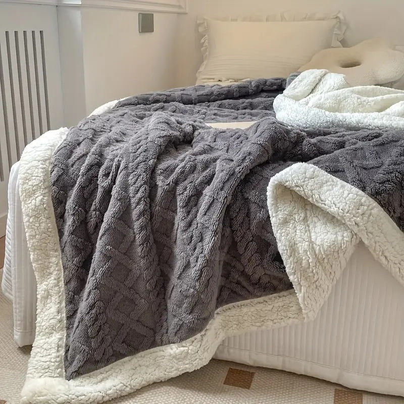 "Luxe sherpa deken in antraciet, gemaakt van premium geborstelde fleecestof, biedt ongeëvenaarde zachtheid en warmte."