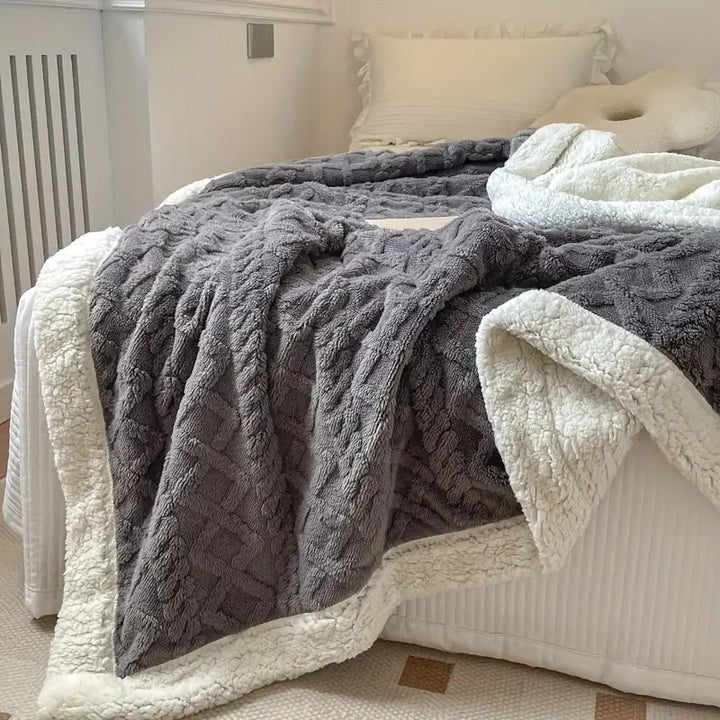 "Luxe sherpa deken in antraciet, gemaakt van premium geborstelde fleecestof, biedt ongeëvenaarde zachtheid en warmte."