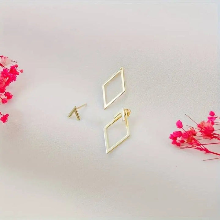 "Minimalistische geometrische oorbellen in goud en zilver met speelse diamant- en pijlvorm, luxe glans en elegante uitstralin