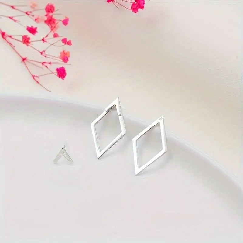"Minimalistische geometrische oorbellen in goud en zilver met speelse diamant- en pijlvorm, luxe glans en elegante uitstralin