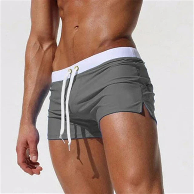 "Moderne heren zwembroek met korte lengte, goudkleurige oogjes, verstelbare taille en zijsplitten voor comfort en stijl."