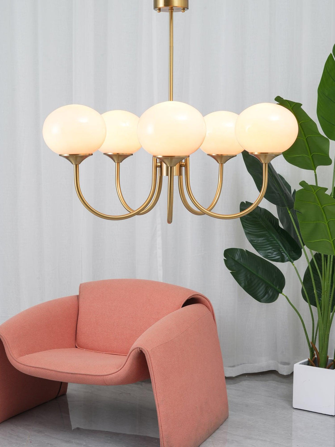 "Moderne kroonluchter met gouden afwerking en roze glazen kappen, geschikt voor LED verlichting in eigentijds interieur."