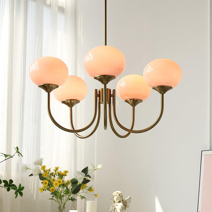 "Moderne kroonluchter met gouden afwerking en roze glazen kappen, geschikt voor LED verlichting in eigentijds interieur."