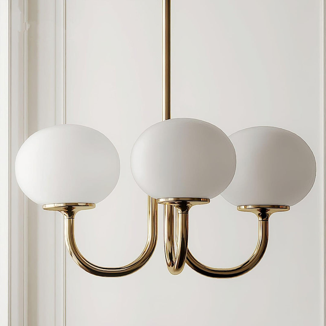 "Moderne kroonluchter met gouden afwerking en roze glazen kappen, geschikt voor LED verlichting in eigentijds interieur."