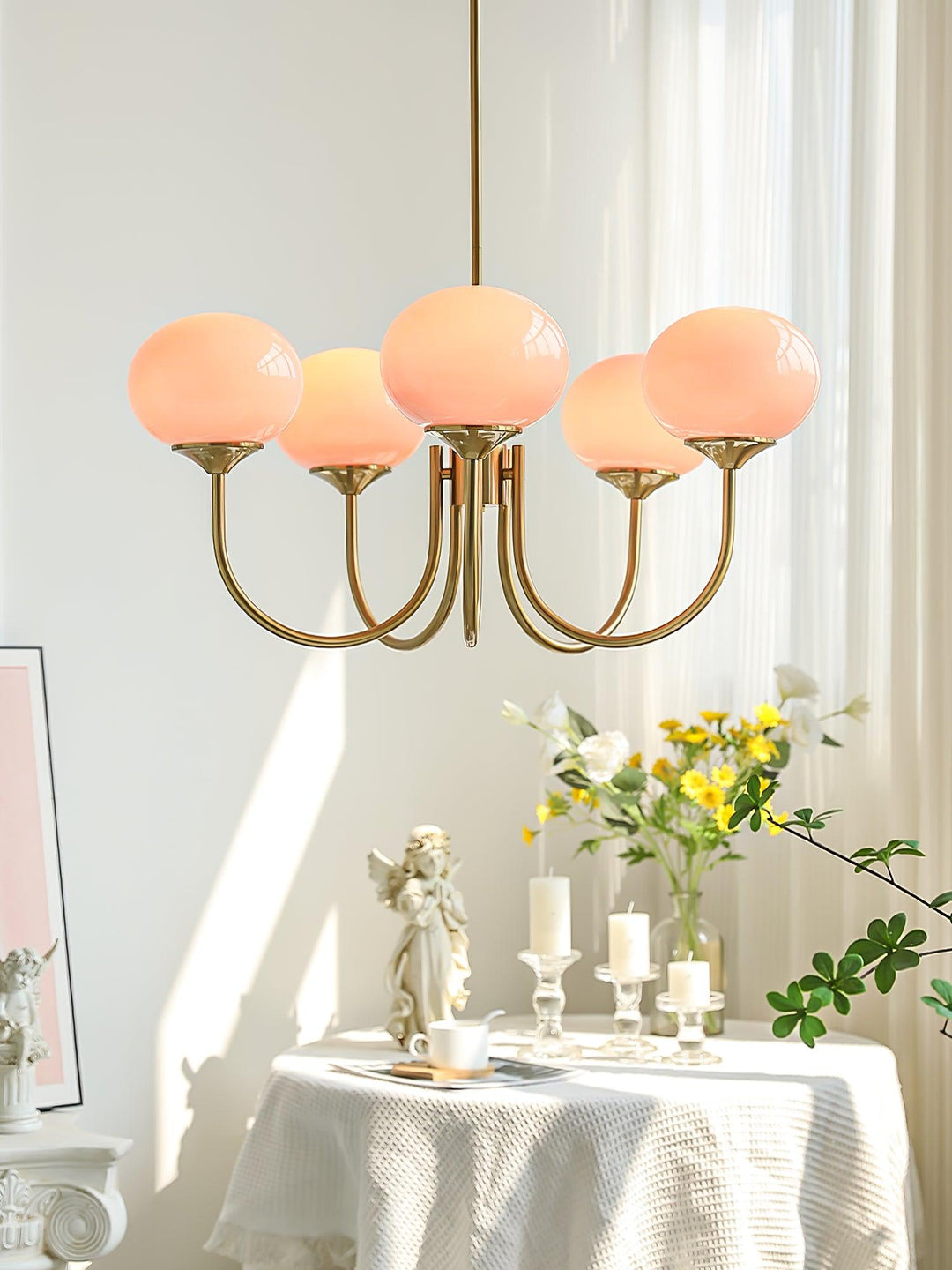 "Moderne kroonluchter met gouden afwerking en roze glazen kappen, geschikt voor LED verlichting in eigentijds interieur."