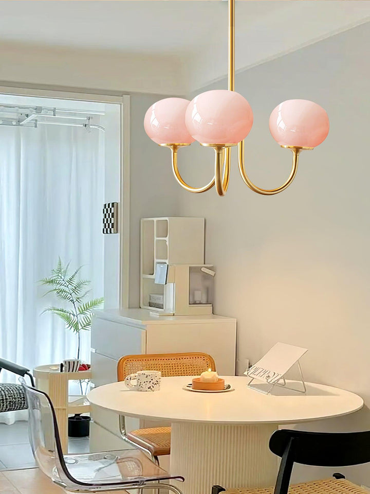 "Moderne kroonluchter met gouden afwerking en roze glazen kappen, geschikt voor LED verlichting in eigentijds interieur."