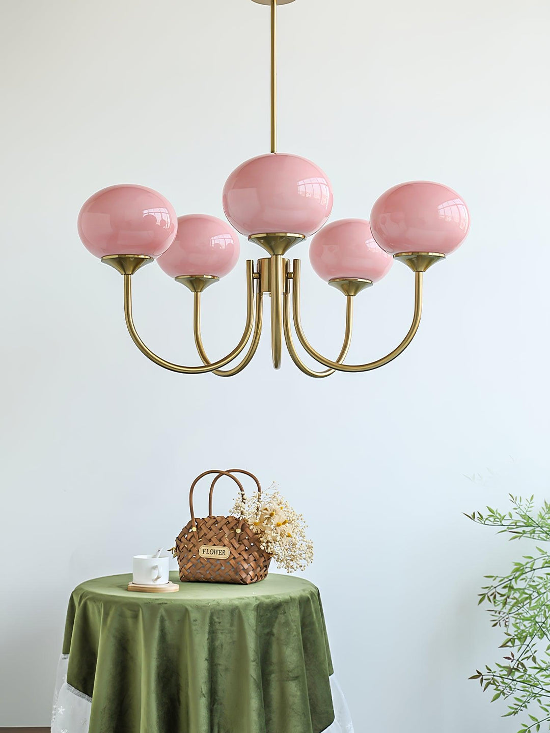 "Moderne kroonluchter met gouden afwerking en roze glazen kappen, geschikt voor LED verlichting in eigentijds interieur."