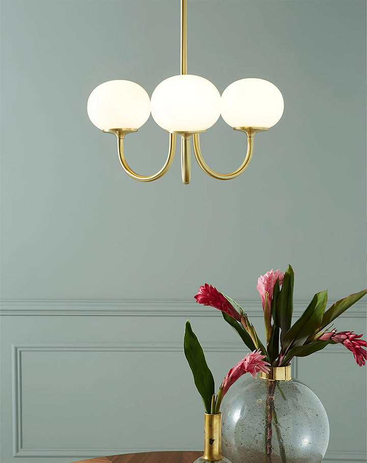 "Moderne kroonluchter met gouden afwerking en roze glazen kappen, geschikt voor LED verlichting in eigentijds interieur."