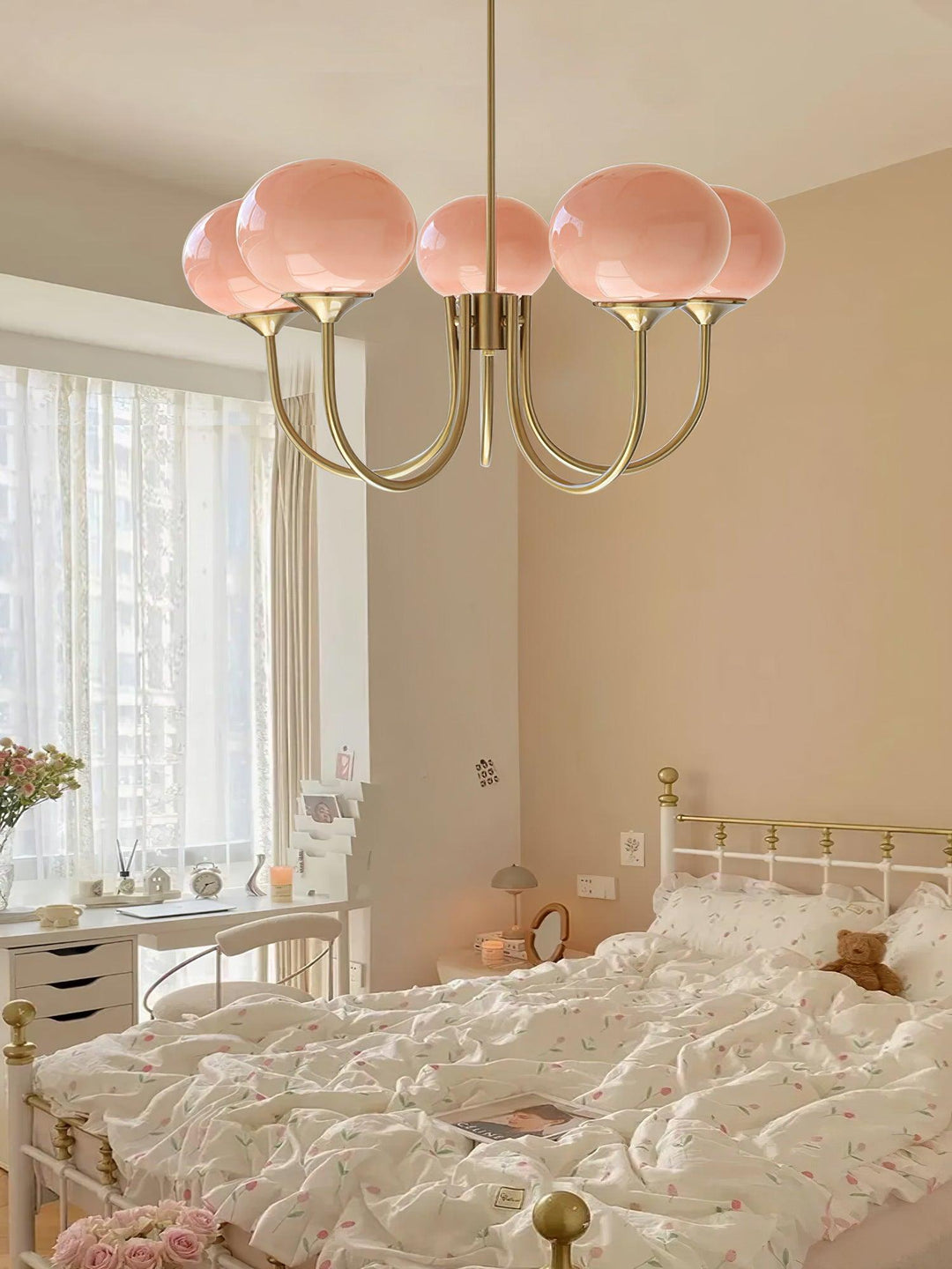 "Moderne kroonluchter met gouden afwerking en roze glazen kappen, geschikt voor LED verlichting in eigentijds interieur."