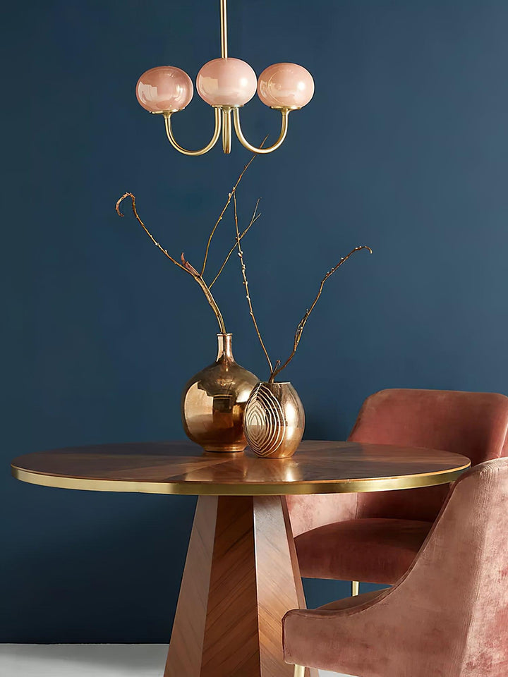 "Moderne kroonluchter met gouden afwerking en roze glazen kappen, geschikt voor LED verlichting in eigentijds interieur."