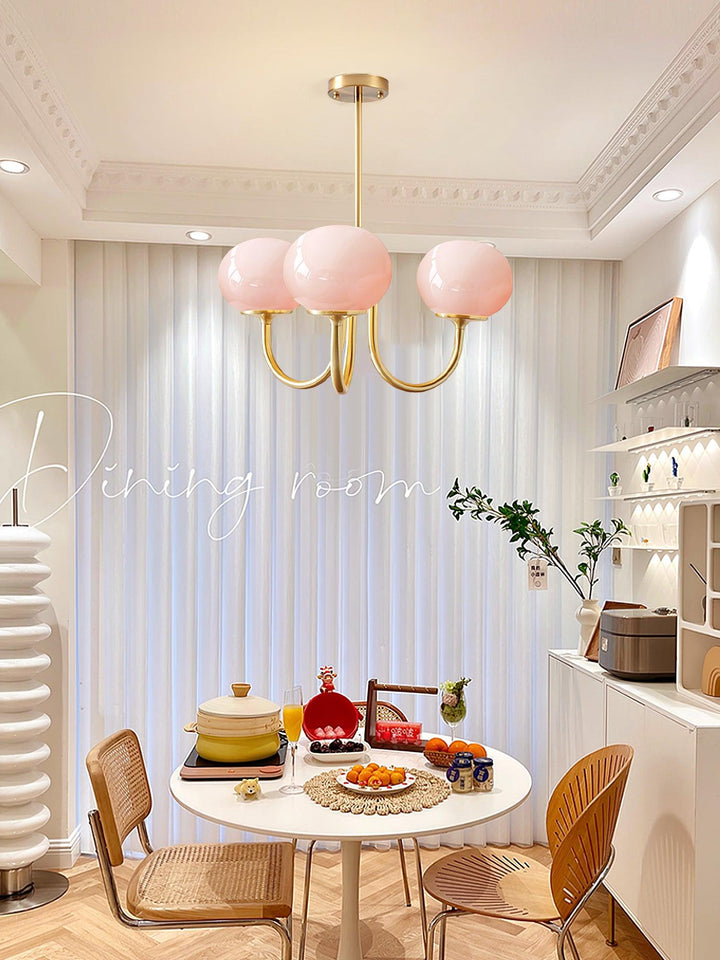 "Moderne kroonluchter met gouden afwerking en roze glazen kappen, geschikt voor LED verlichting in eigentijds interieur."