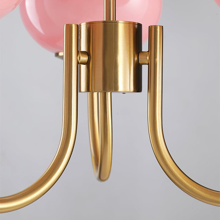 "Moderne kroonluchter met gouden afwerking en roze glazen kappen, geschikt voor LED verlichting in eigentijds interieur."