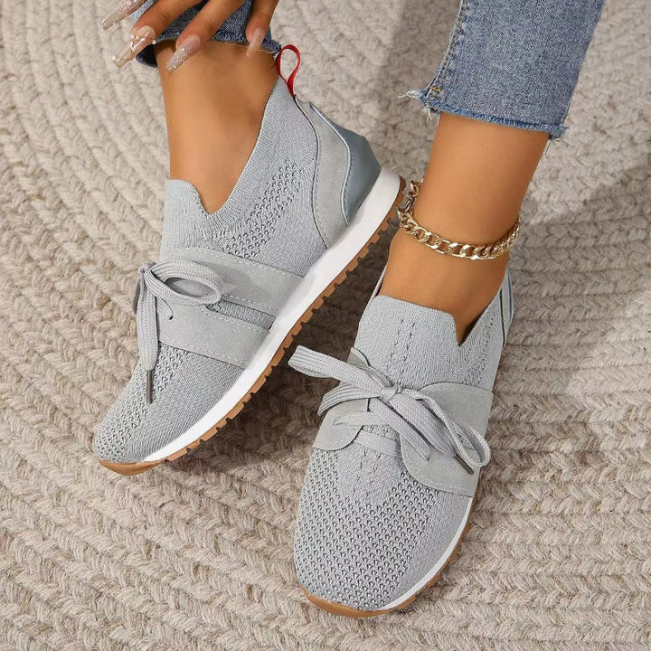 "Modieuze orthopedische sneakers voor dames, grijs met roze accenten, ergonomisch ontwerp voor comfort en stijl."