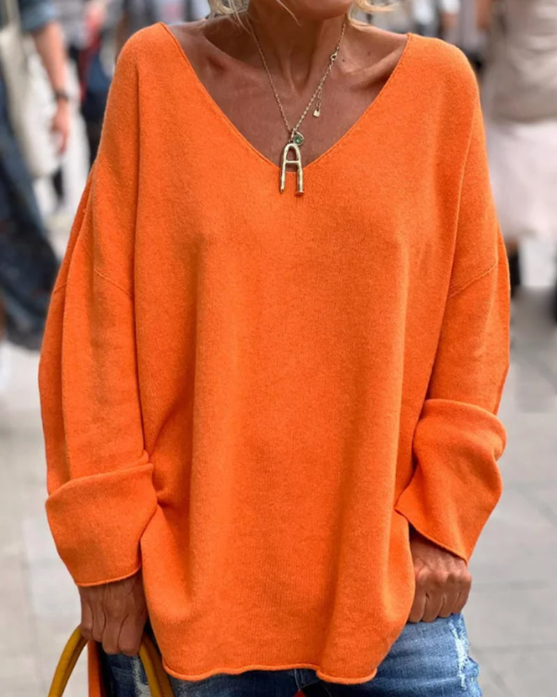 "Oranje dames tanktop met V-hals, losse pasvorm en elegante splitdetails, perfect voor casual of avondoutfits."