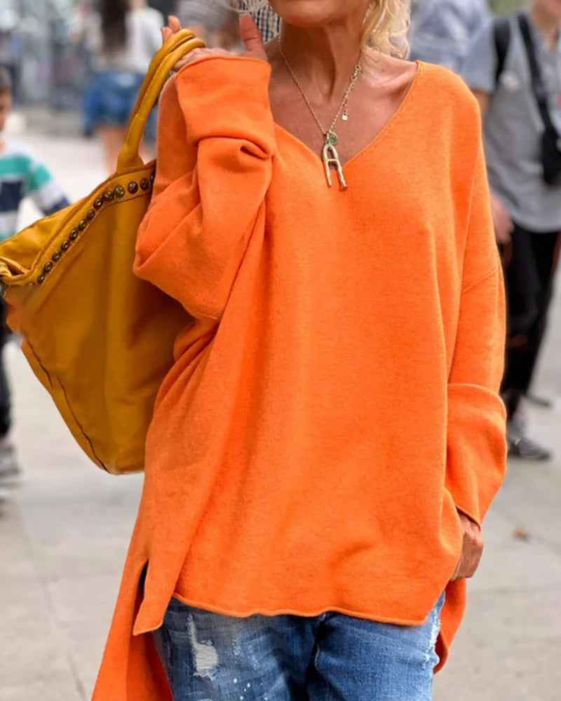 "Oranje dames tanktop met V-hals, losse pasvorm en elegante splitdetails, perfect voor casual of avondoutfits."