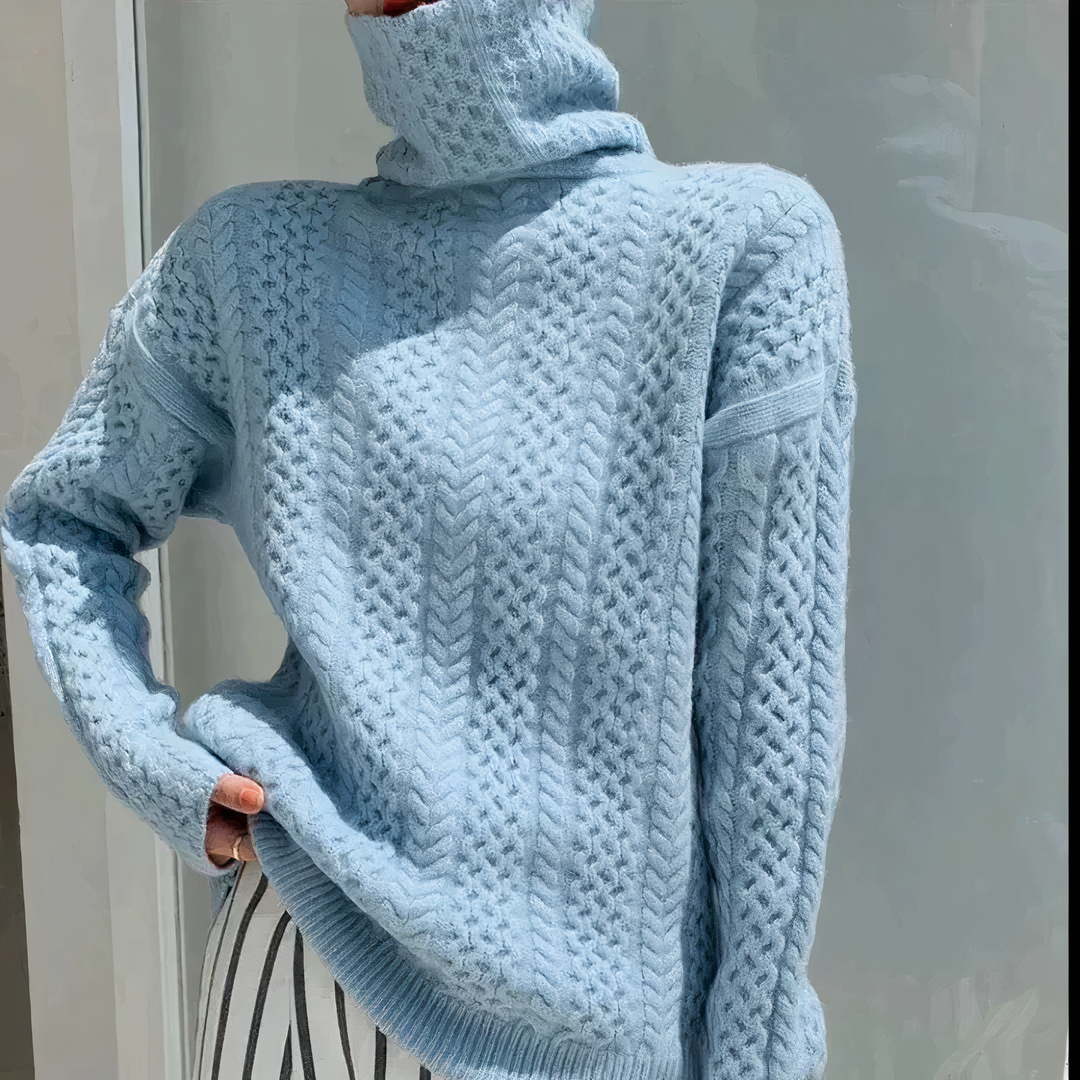 "Romige kasjmier coltrui Talia met elegant kabelpatroon; biedt ultiem comfort en stijl in zachte beige tinten."