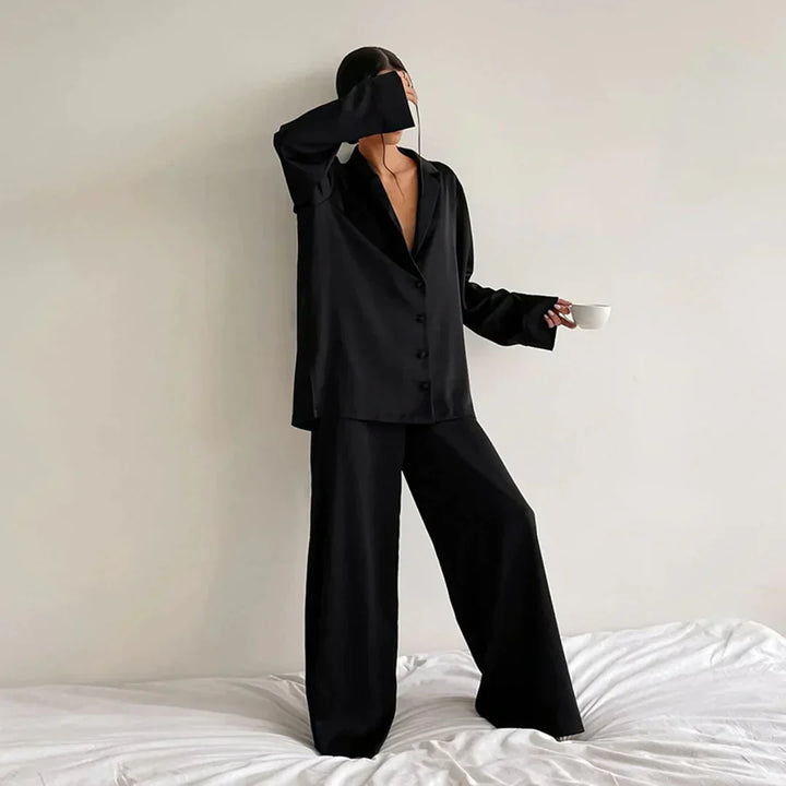 "Satijnen dames pyjama set met wijde broek, elegante blouse en subtiele glans. Comfortabel loungen in luxe stijl."
