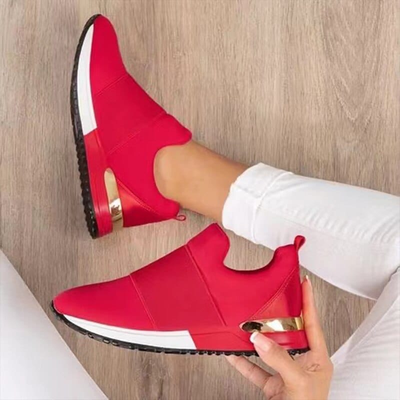 "Stijlvolle beige en rode damessneakers met gouden accenten, ademend bovenwerk en comfortabele pasvorm op houten vloer."
