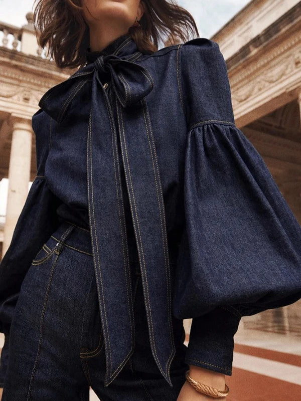 "Stijlvolle denimbloes met grote strik en ballonmouwen, vrouwelijke top in zachte denim voor een moderne uitstraling."