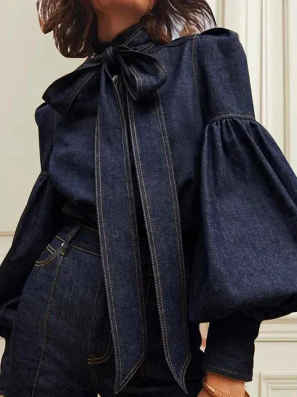 "Stijlvolle denimbloes met grote strik en ballonmouwen, vrouwelijke top in zachte denim voor een moderne uitstraling."