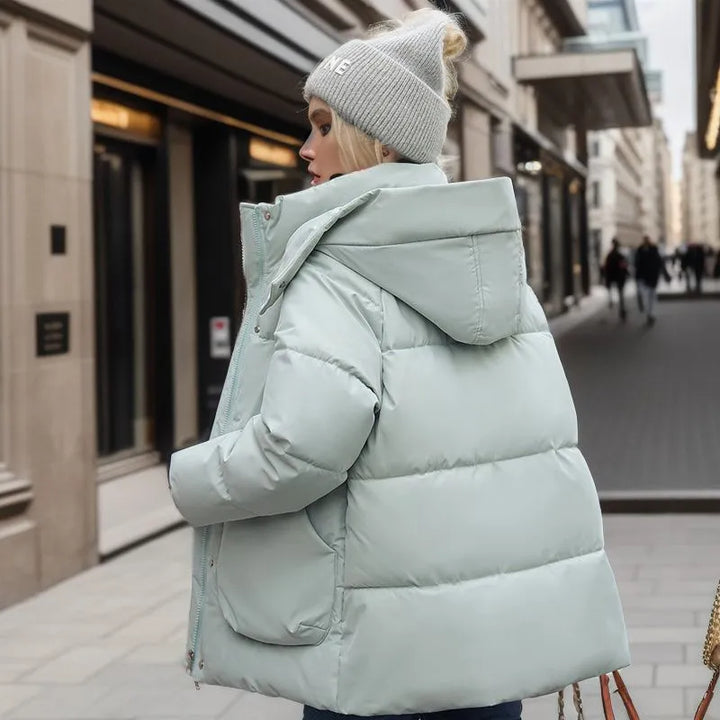 "Stijlvolle winter pufferjas voor dames in wit met dons- en katoenvulling, wind- en waterbestendig, met verstelbare capuchon.