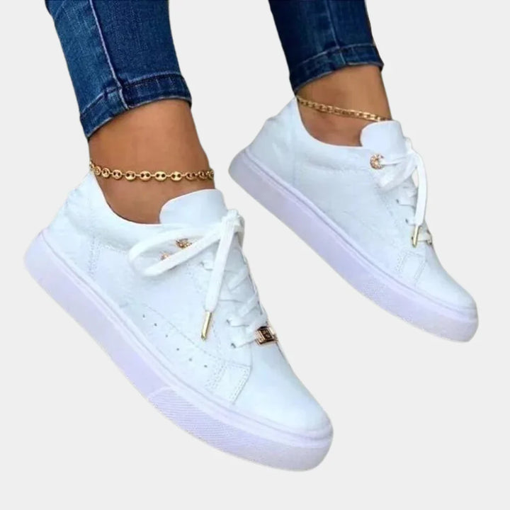 "Stijlvolle witte damessneakers van kunstleer met dempende zool, elegant design voor casual en semi-formele outfits."
