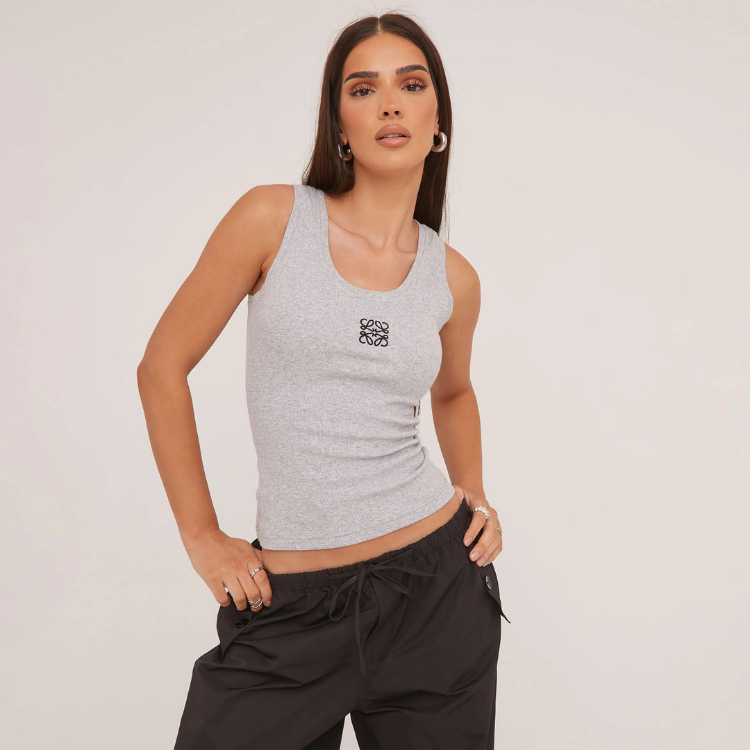 "Tanktop van zijdezacht katoen met minimalistisch design, ideaal voor zomer. Verkrijgbaar in grijs, wit en zwart."