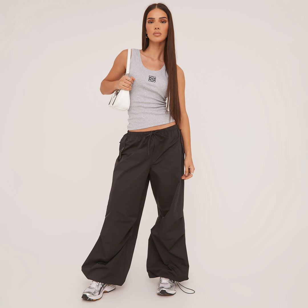 "Tanktop van zijdezacht katoen met minimalistisch design, ideaal voor zomer. Verkrijgbaar in grijs, wit en zwart."