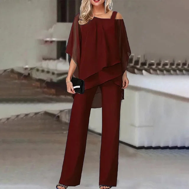 "Tweedelige chiffon set met asymmetrische top en wijde pijpen, elegante off-shoulder details, luchtig en stijlvol."