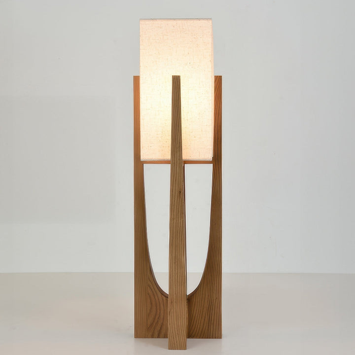 Vloerlamp met walnotenhouten basis, messing accenten en katoenen kap; minimalistisch en elegant voor sfeervol interieur.