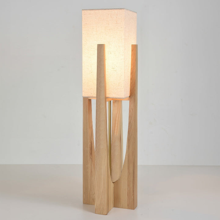 Vloerlamp met walnotenhouten basis, messing accenten en katoenen kap; minimalistisch en elegant voor sfeervol interieur.