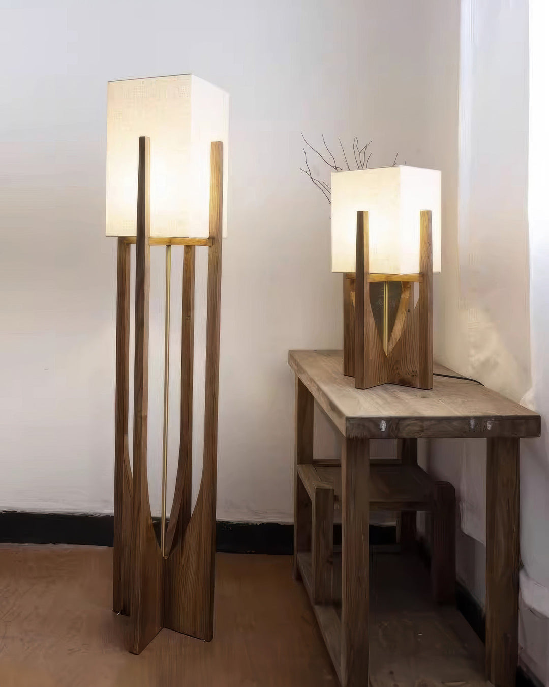 Vloerlamp met walnotenhouten basis, messing accenten en katoenen kap; minimalistisch en elegant voor sfeervol interieur.