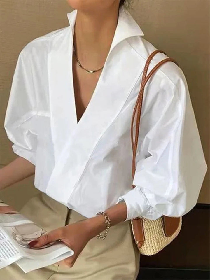 "Witte damesblouse met V-hals en pofmouwen, gemaakt van katoenmengsel. Casual ontwerp, ideaal voor lente en zomer."