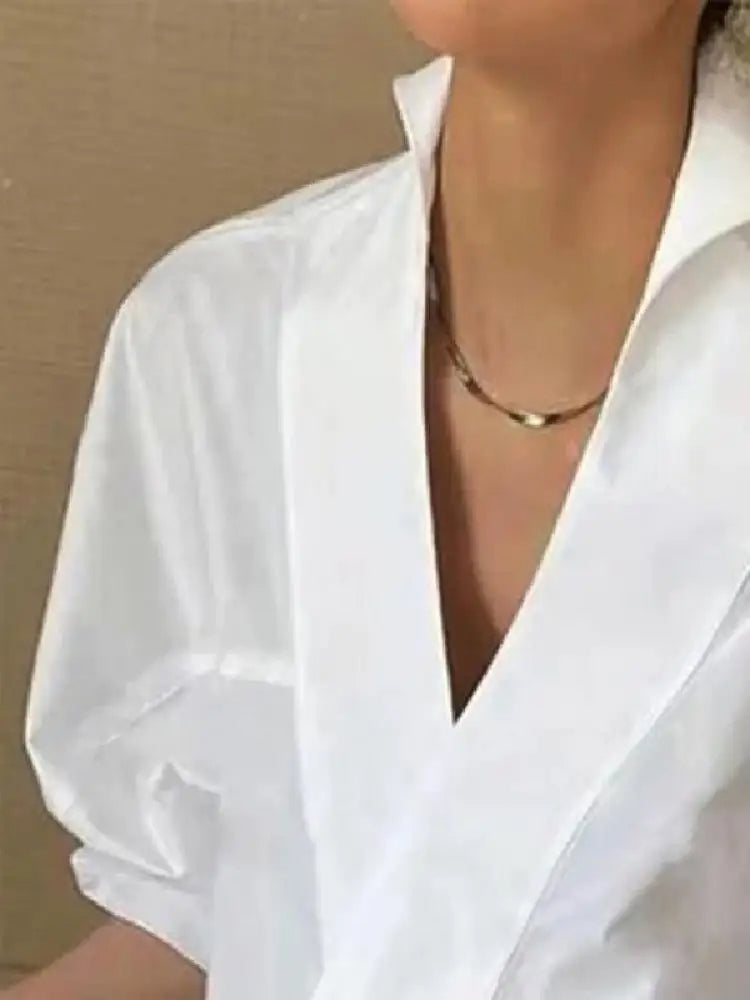 "Witte damesblouse met V-hals en pofmouwen, gemaakt van katoenmengsel. Casual ontwerp, ideaal voor lente en zomer."