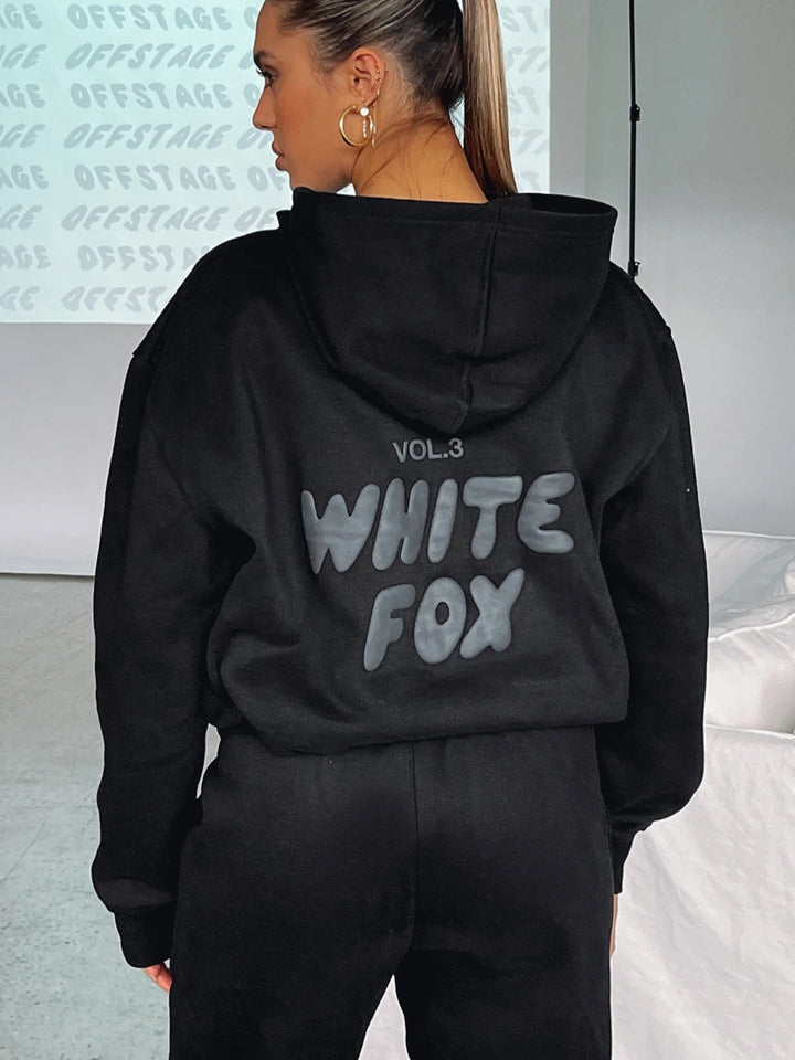 "Witte Vos trainingspak heren, loose fit, vooraanzicht met oversized silhouet en opvallend pofdruklogo."