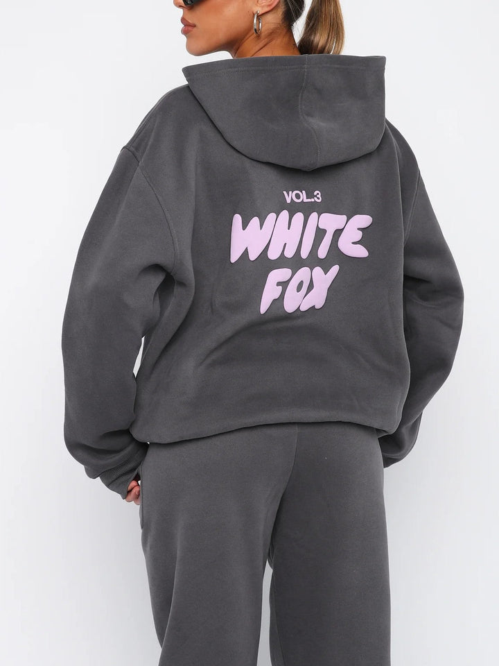 "Witte Vos trainingspak heren, loose fit, vooraanzicht met oversized silhouet en opvallend pofdruklogo."