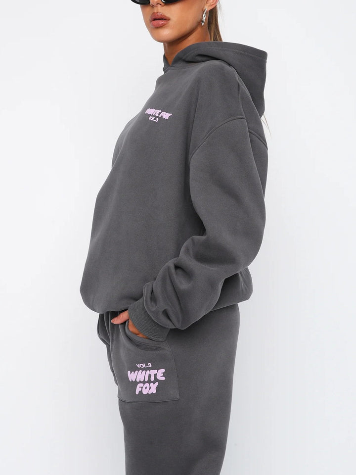 "Witte Vos trainingspak heren, loose fit, vooraanzicht met oversized silhouet en opvallend pofdruklogo."