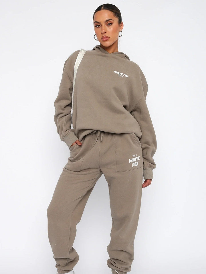 "Witte Vos trainingspak heren, loose fit, vooraanzicht met oversized silhouet en opvallend pofdruklogo."