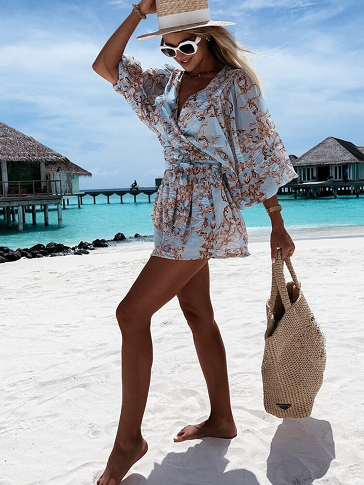 "Zomerse playsuit met V-hals, fruit- en bladmotieven, kleurrijke tropische print, accentueert silhouet en biedt comfort."